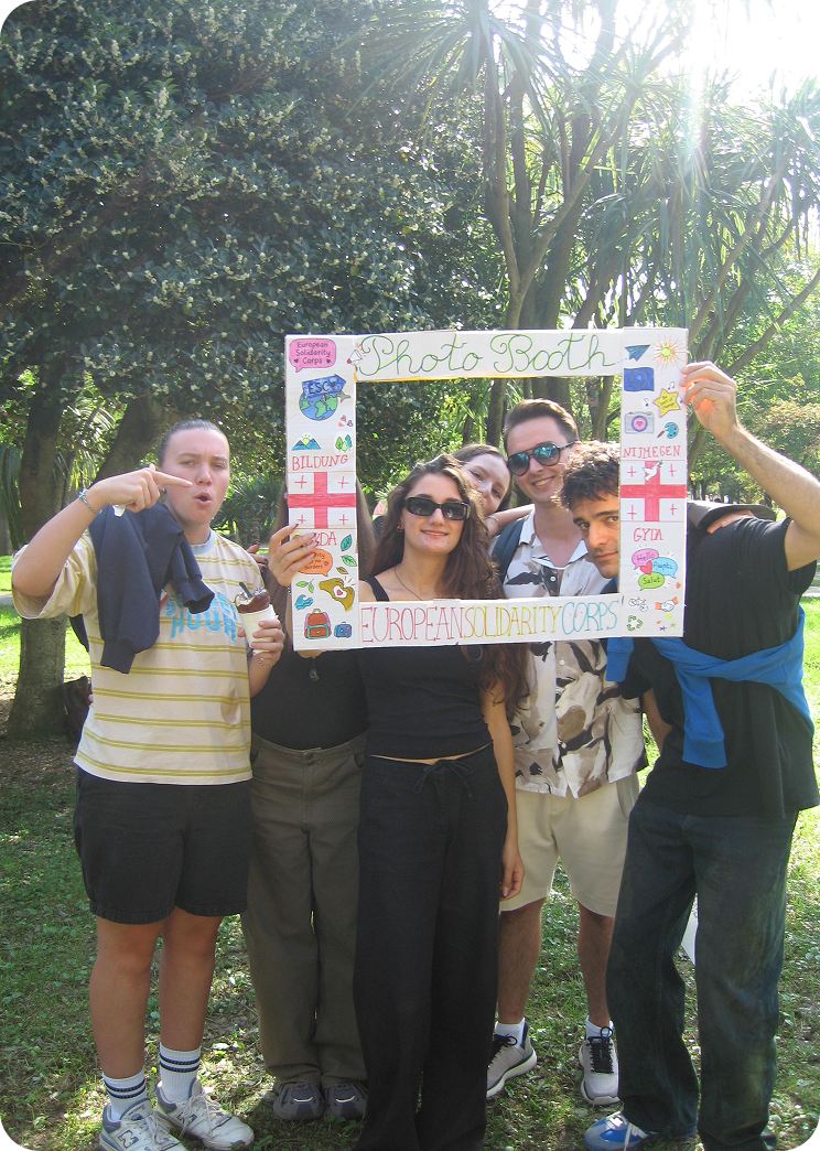 Volunteers posing with a photo frame during a community event
